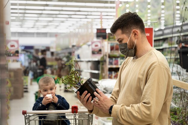 Side view man looking at potted plant