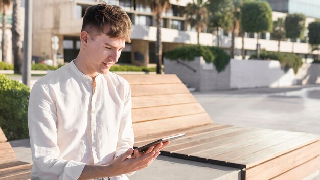 屋外のタブレットを見て男の側面図