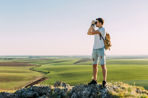 Side view of a man looking through binoculars