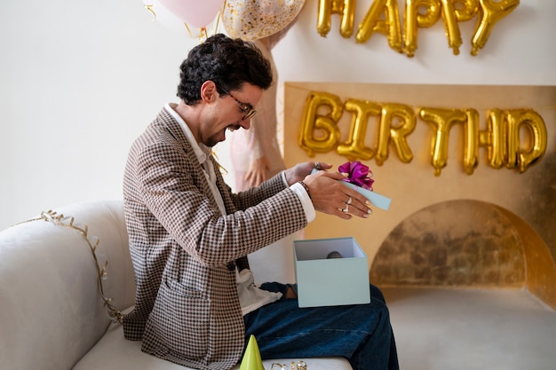 Free photo side view man opening present