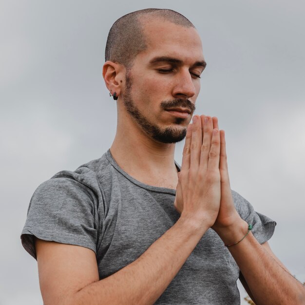 Side view of man outside doing yoga