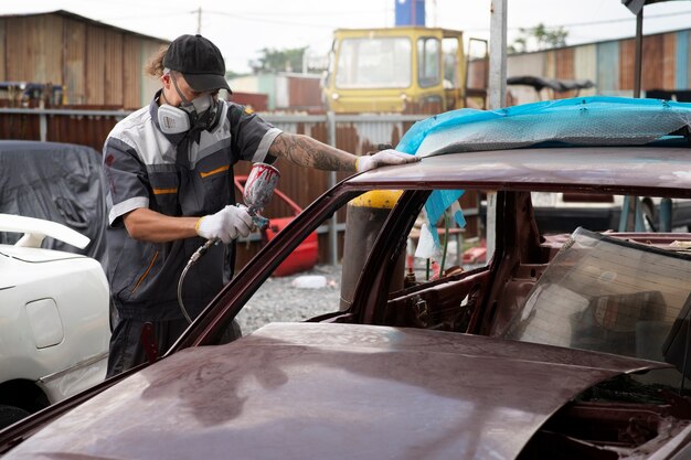 Side view man painting car