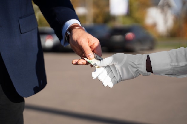 Foto gratuita uomo di vista laterale che paga il parcheggiatore