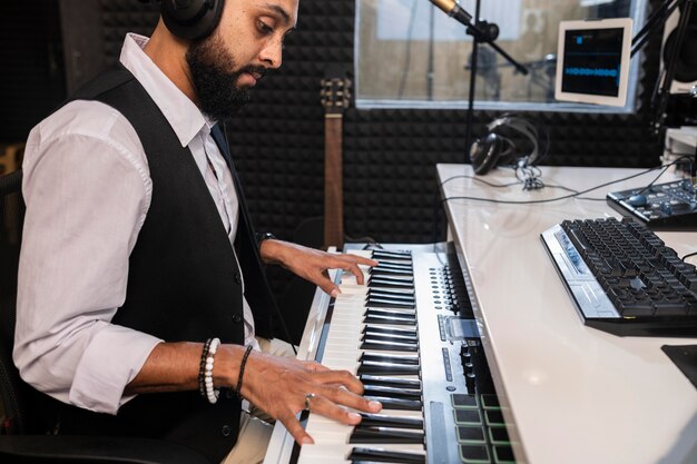 Side view man playing the piano at a radio station
