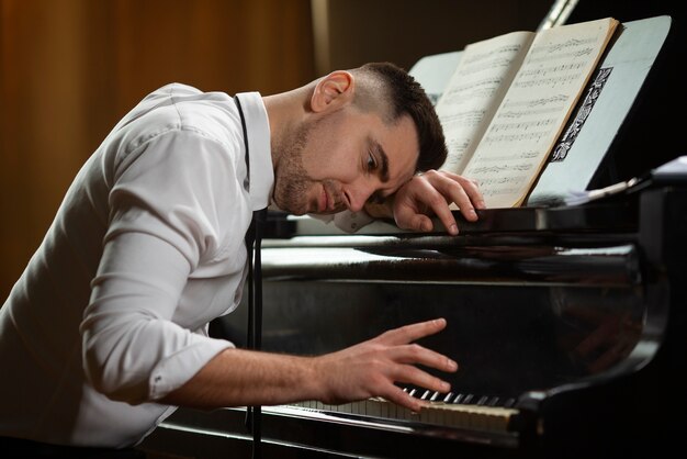 Vista laterale uomo che suona il pianoforte