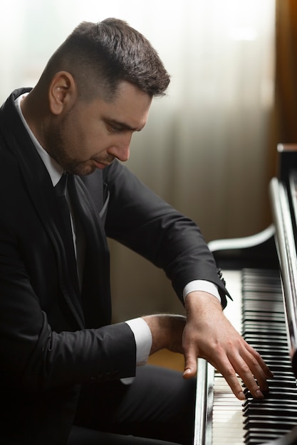 Foto gratuita vista laterale uomo che suona il pianoforte