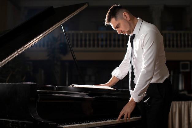 Vista laterale uomo che suona il pianoforte