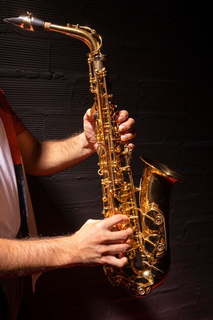 Вид сбоку человека, играющего на саксофоне