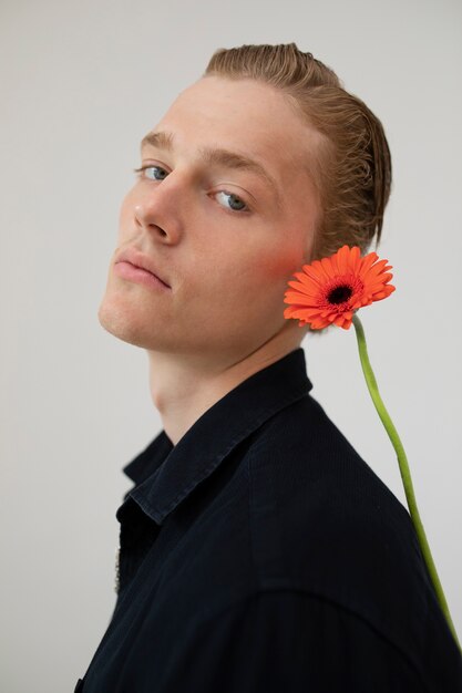 Side view man posing with flower