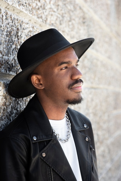 Free photo side view man posing with hat