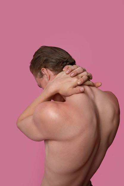 Side view man posing with pink background