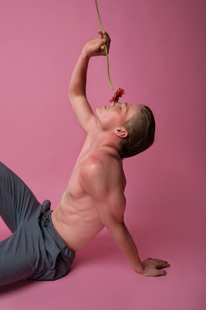 Side view man posing with red flower