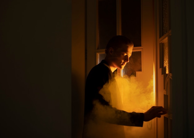 Side view man posing with smoke