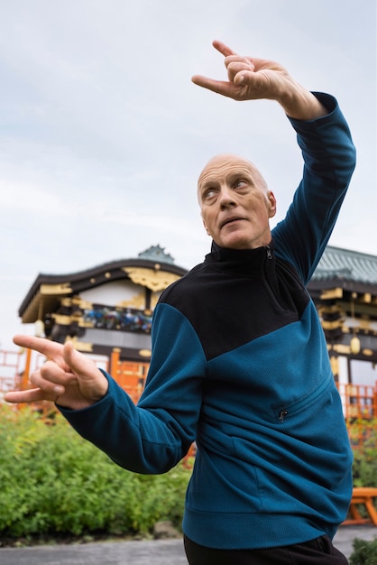 Side view man practicing tai chi