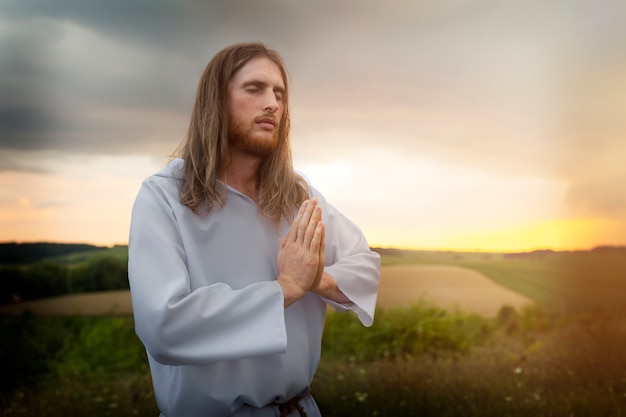 Free photo side view man praying outdoors