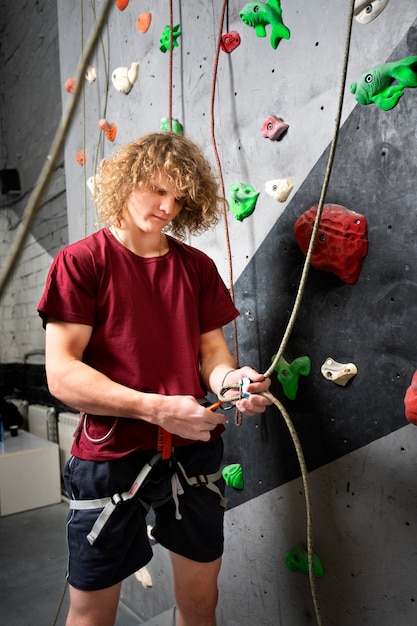 Free photo side view man preparing to climb wall