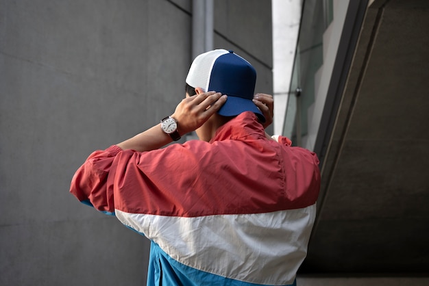 Free photo side view man putting on trucker hat