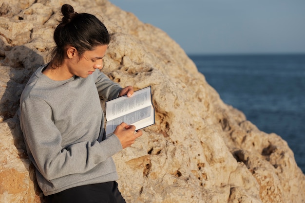 Side view man reading at beach