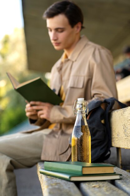 Free photo side view man reading book outdoors