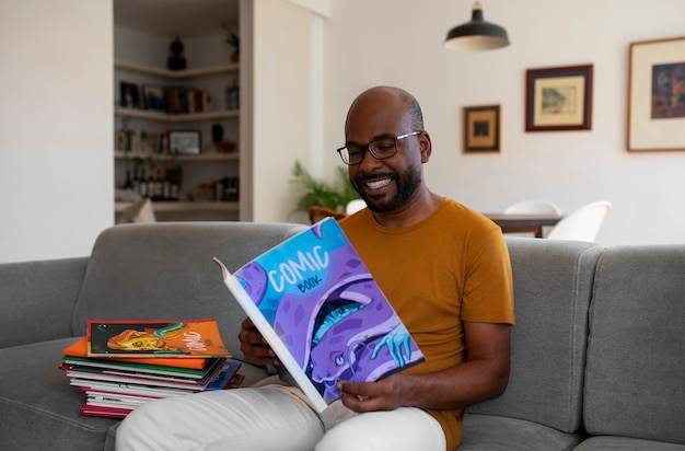 Free photo side view man reading comics at home