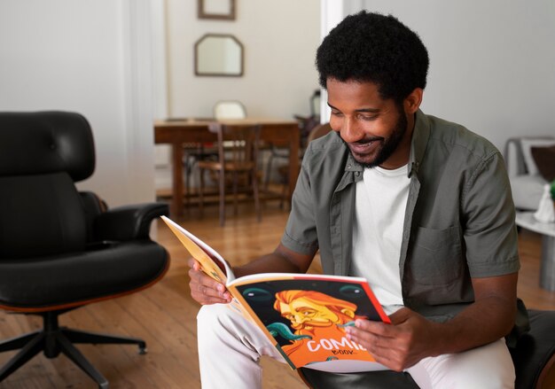 Side view man reading comics at home
