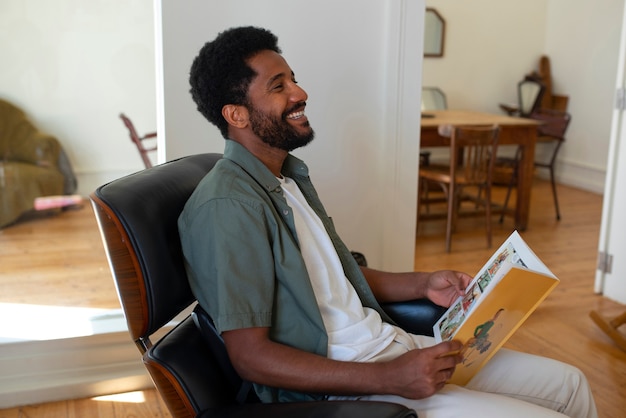 Side view man reading comics at home