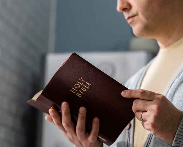 Side view of man reading from the bible