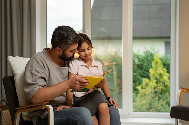 Free photo side view man reading to girl