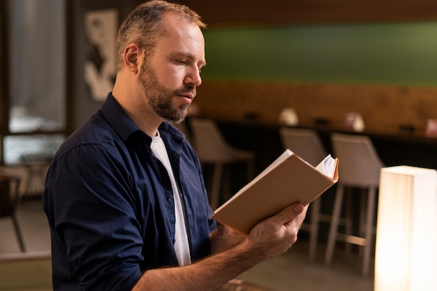 Side view man reading indoors