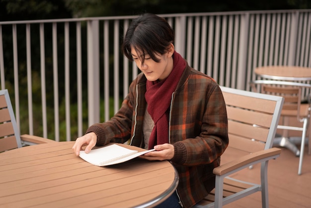 Free photo side view of man reading outdoors