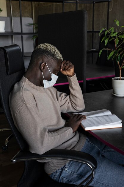 Side view man reading with mask