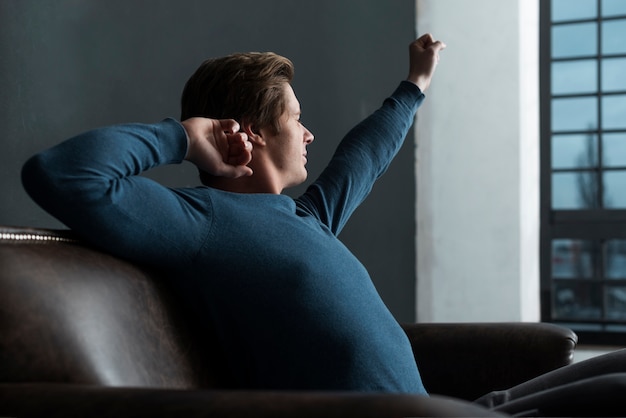 Side view man relaxing indoors