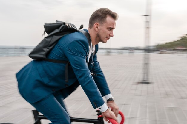 Side view man riding a bike to work