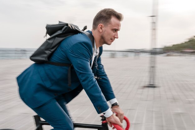 Вид сбоку человек, едущий на велосипеде на работу