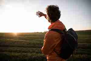 Foto gratuita vista laterale dell'uomo in viaggio ammirando la vista e il sole