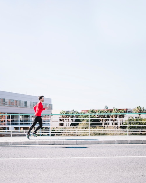 Foto gratuita uomo di vista laterale che corre vicino alla strada