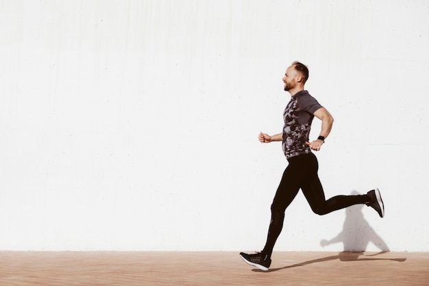 Side view of a man running on street