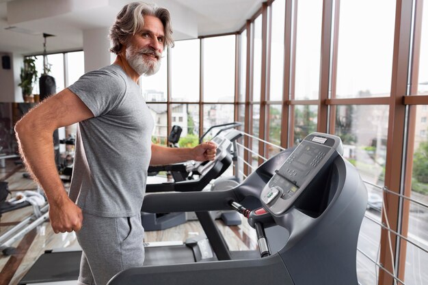 Side view man running on treadmill