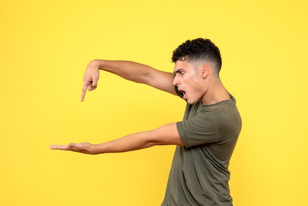 Foto gratuita vista laterale l'uomo il ragazzo scioccato punta il dito sul palmo della mano