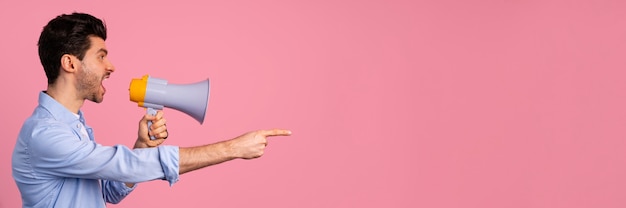 Side view of man shouting in megaphone with copy space