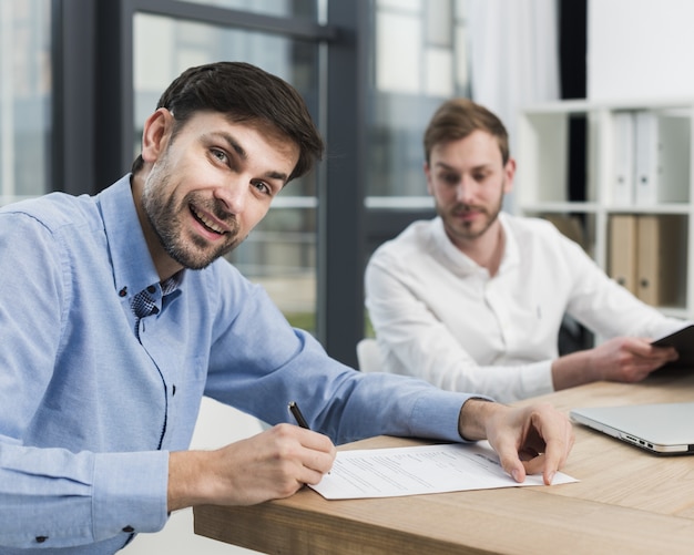 Side view of man signing work contract