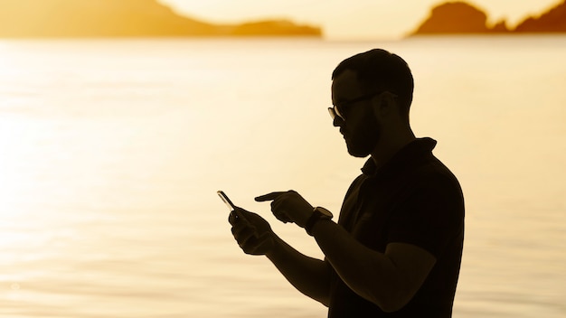 Foto gratuita siluetta dell'uomo di vista laterale in riva al mare