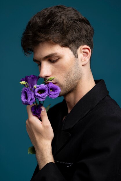 Side view man smelling purple flower