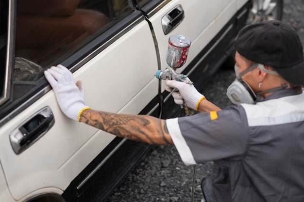 Free photo side view man spraying powder paint