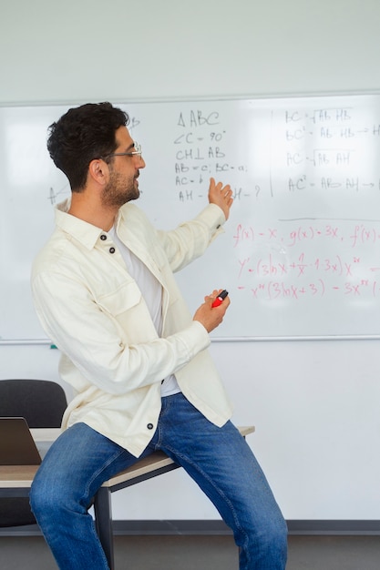 Foto gratuita uomo di vista laterale che studia in aula