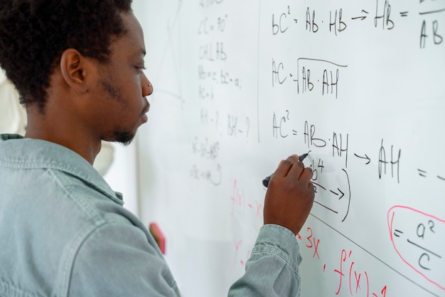 Foto gratuita uomo di vista laterale che studia in aula