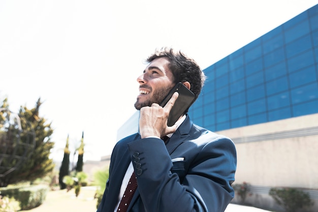 Side view man in suit talking on the phone