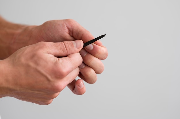 Side view of man taking care of his fingernails