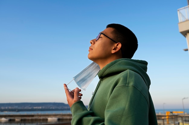 Side view man taking mask off