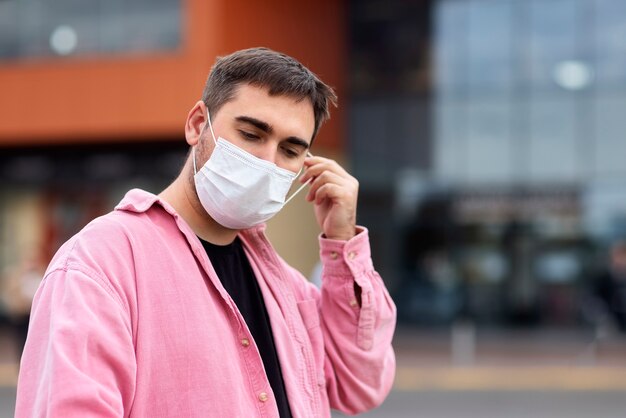 Side view man taking off mask